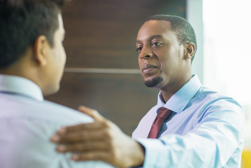 serious-expert-expressing-support-colleague-min